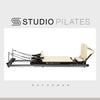 Studio Pilates reformer machine on a white background with 'Studio Pilates' branding.