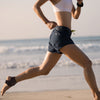 Person running on a beach with ocean in the background