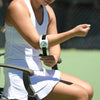 Person on a tennis court wearing a white wristband with a logo.