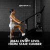 Woman using a Stepr Go stair climber against a brick wall.