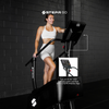 Woman using a Stepr Go treadmill with a black brick wall background