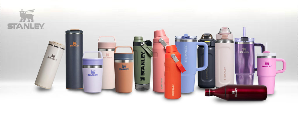 Collection of Stanley branded thermos bottles in various colors on a light gray background